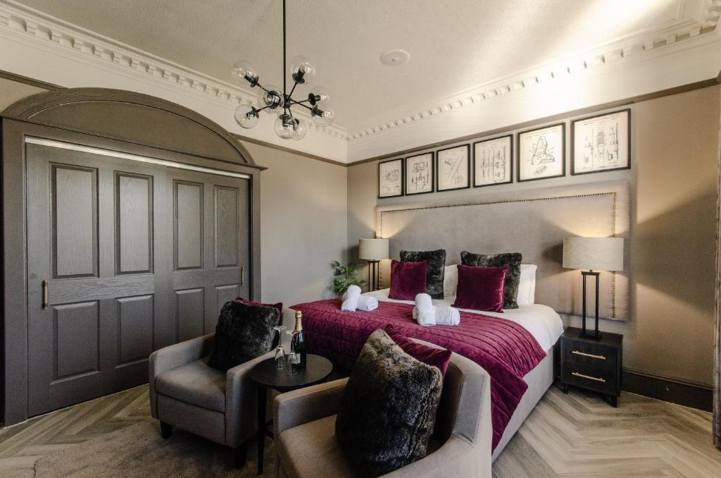 a bedroom with a large bed and two chairs at Sweeney Aviemore Two in Aviemore