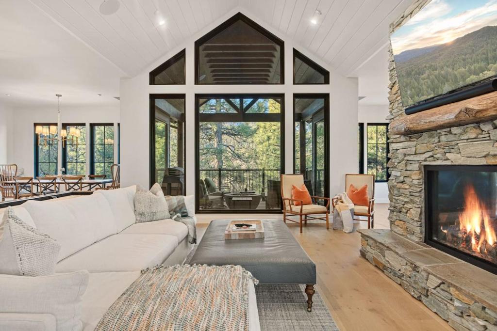 Luxury Ridgecrest Resort 4BR في بيغ بير لاكي: غرفة معيشة مع أريكة بيضاء ومدفأة