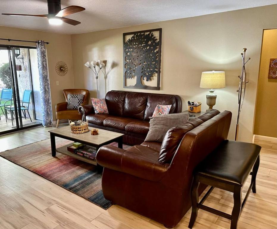 a living room with a leather couch and a table at Serenity Now in Beautiful Sedona - 3 BR 2 BA in Sedona
