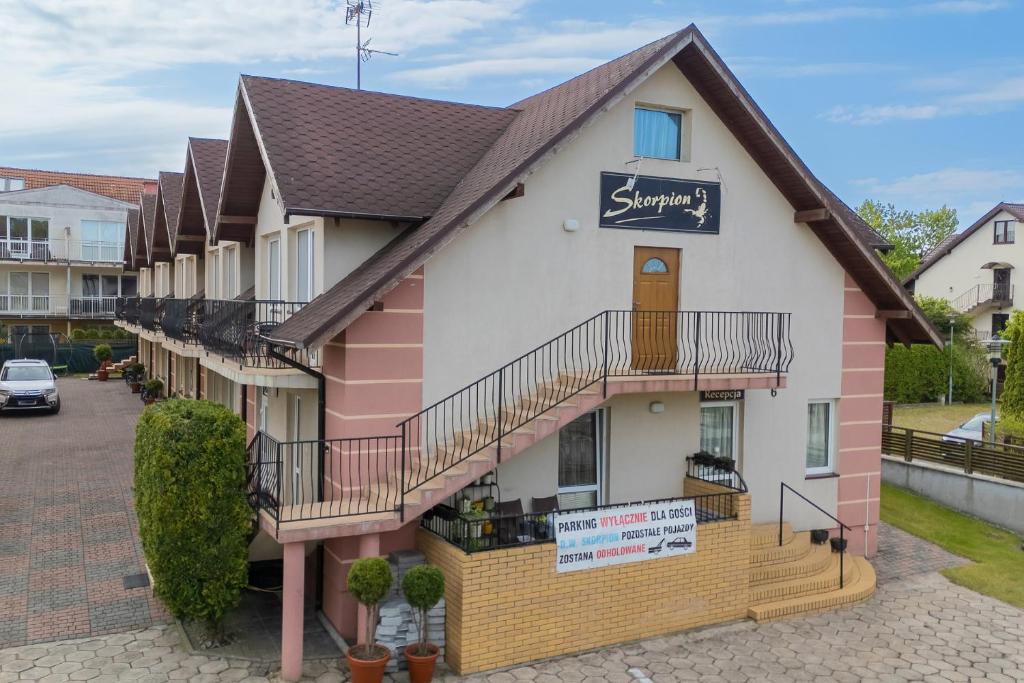 a pink and white building with a sign on it at Skorpion in Rewal