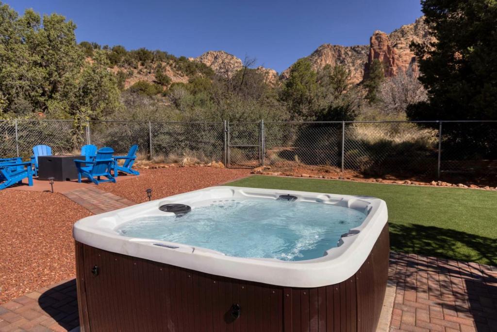 a hot tub in a yard with mountains in the background at Peaceful Desert Hideaway in Sedona