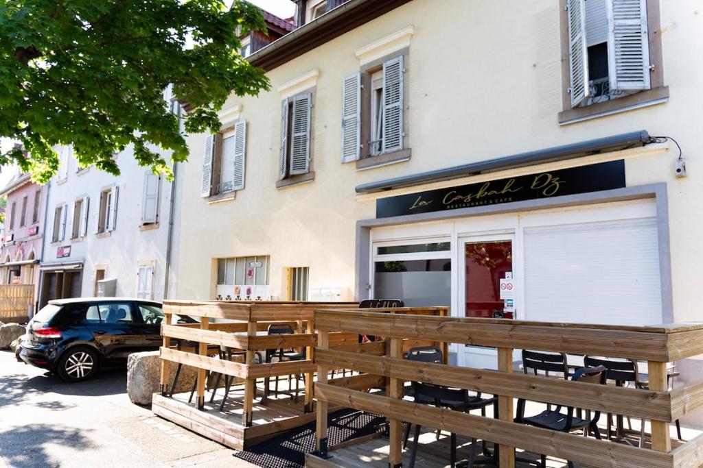 un restaurant avec bancs en bois devant un bâtiment dans l'établissement Duplex cosy- proche centre ville, à Colmar