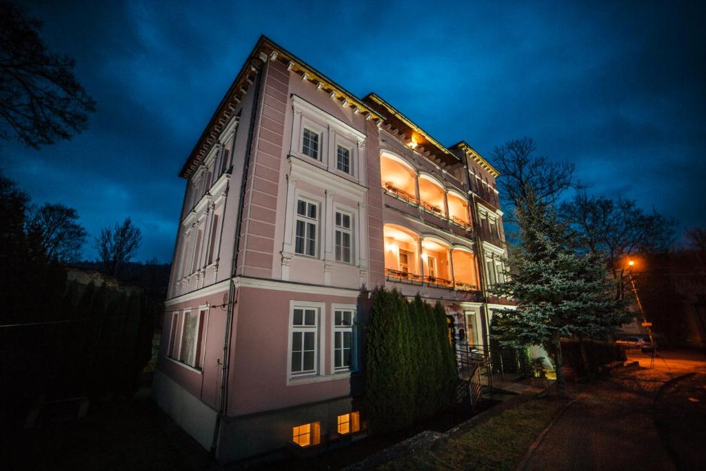 a large house with lights on it at night at Willa Arabeska in Lądek-Zdrój