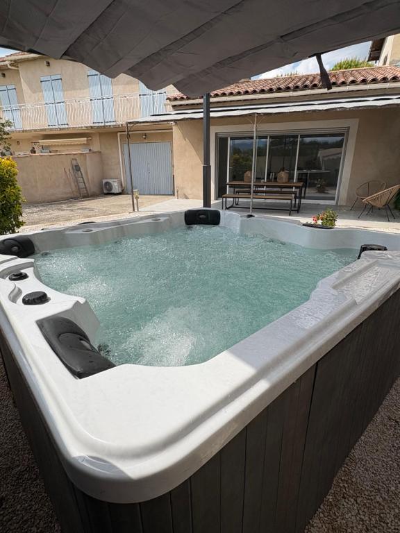 une baignoire jacuzzi dans une cour à côté d'une maison dans l'établissement maison Mila, à Gardanne