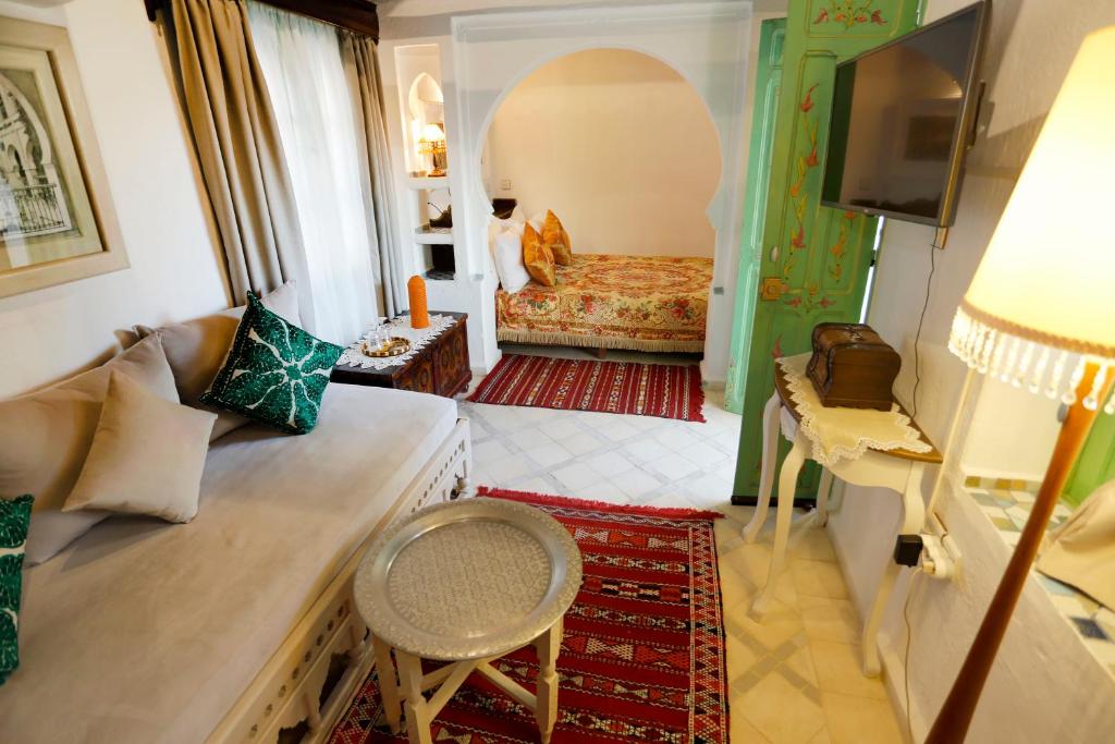a living room with a couch and a bed at Riad Cherifa in Chefchaouene