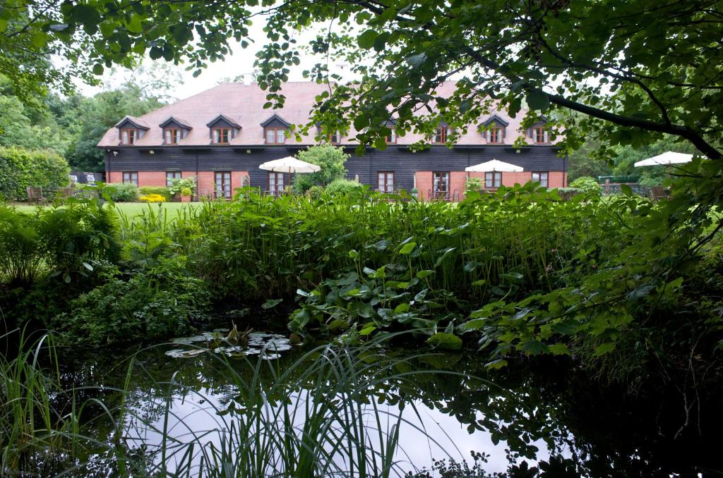 una casa grande con un estanque frente a ella en Ellington Lodge at The Concorde en Eastleigh