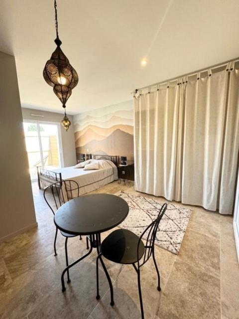 une pièce avec une table, des chaises et un lit dans l'établissement Le Studio Délice, à Challans