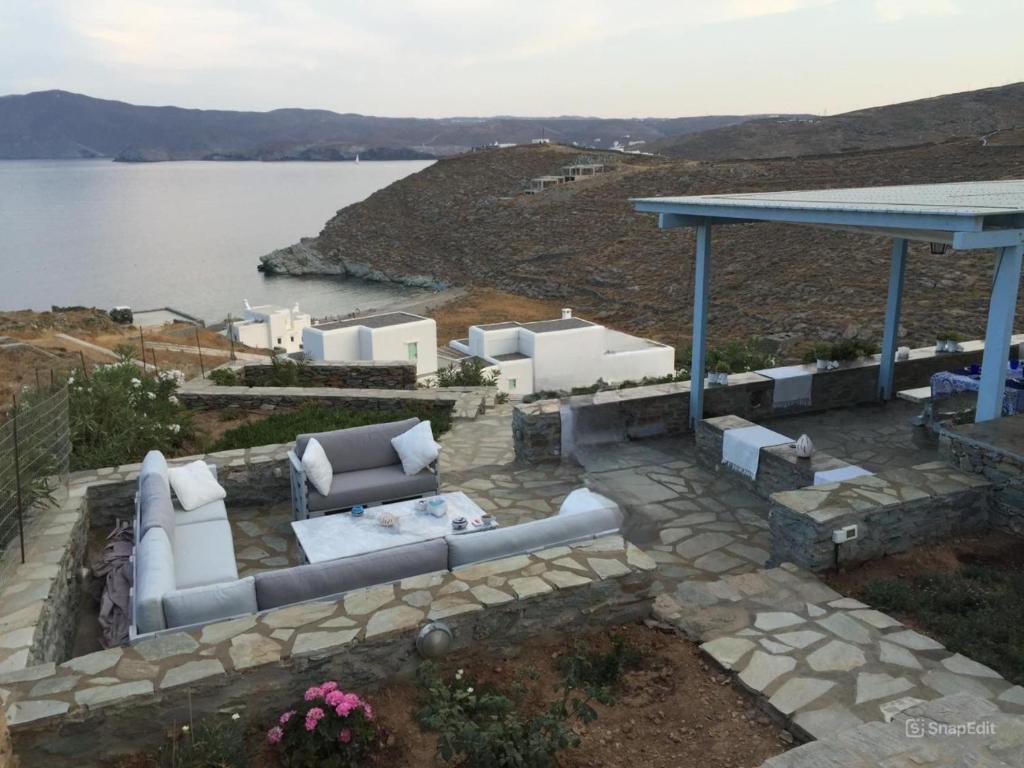 a patio with couches and a view of the water at Phaedra Villa Kythnos in Kithnos