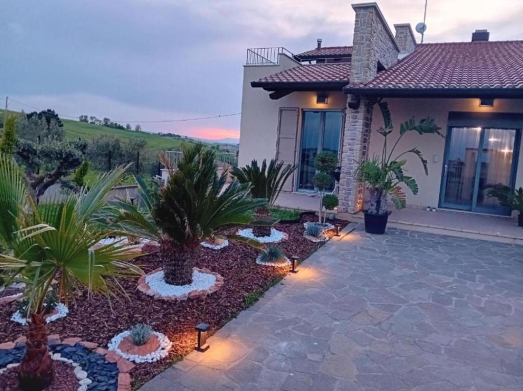 Una casa con jardín con palmeras y luces. en Luxury Villa Daisy, en San Giorgio di Pesaro