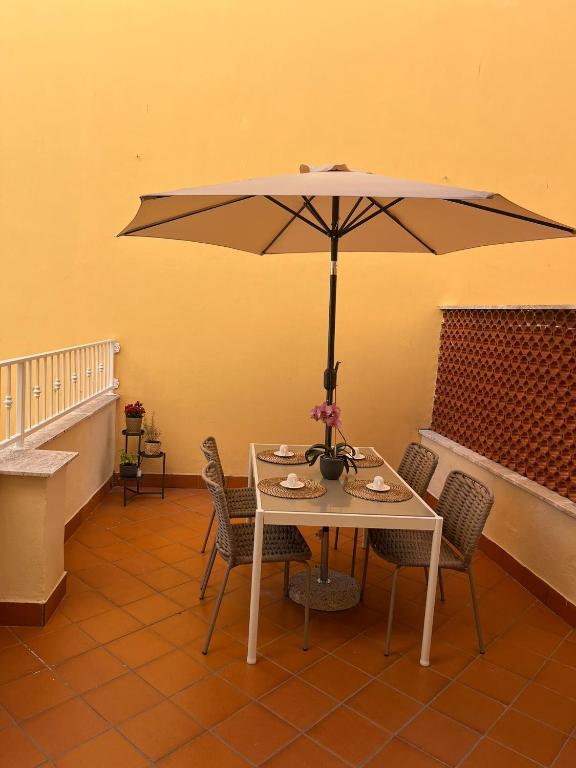 a table and chairs with an umbrella in a room at L'Aurora Casa Vacanze in Anzio