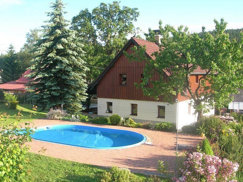 a house with a swimming pool in front of a house at U Javoru in Albrechtice v Jizerských horách