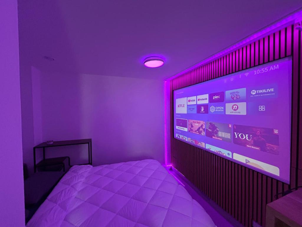 une chambre avec un grand écran avec des lumières violettes dans l'établissement Studio Smart & Design - Cannes, à Cannes