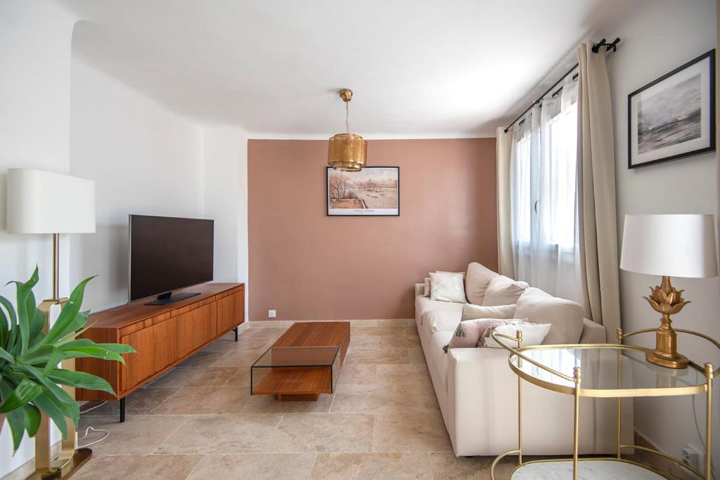 un salon avec un canapé et une télévision dans l'établissement Beautiful apartment of 65 m2 in the 8th Marseille, à Marseille