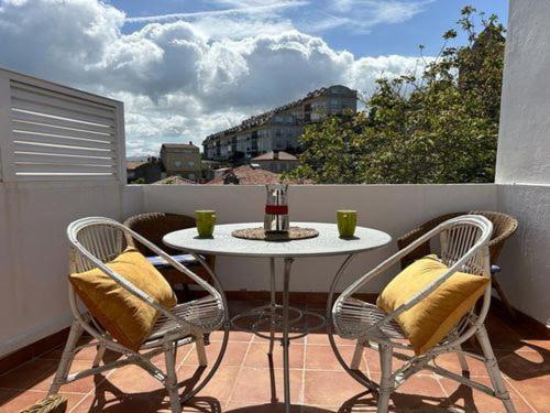 a white table and chairs on a balcony with a view at Baiona Curuxa in Baiona