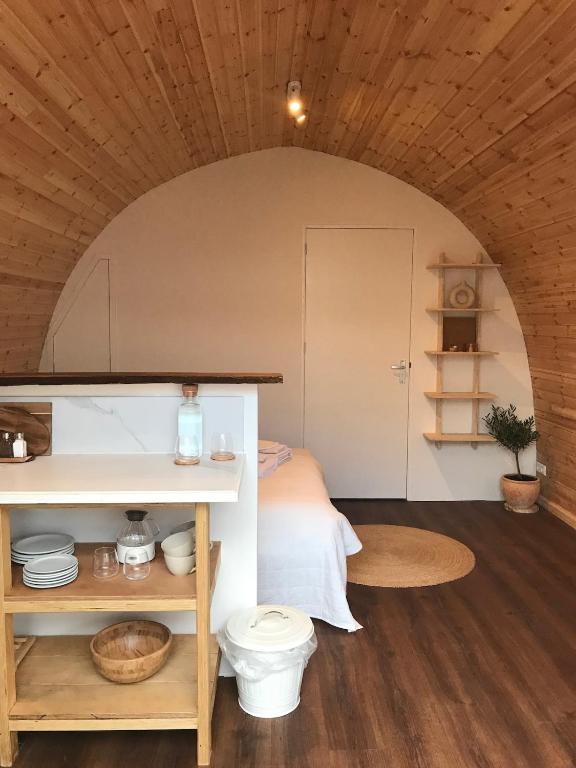 a room with a bed and a table with a toilet at Very unique 'tiny house' with Hottub in Rijsenhout