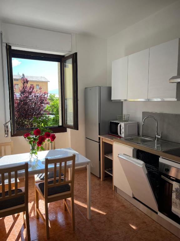 a kitchen with a table and chairs and a kitchen with a window at ALPI & RELAX Sondrio - zona Ospedale - centro città in Sondrio