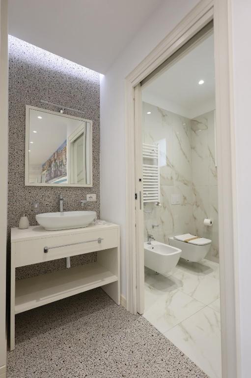 bagno bianco con lavandino e specchio di Nazzarì B&B Tropea a Tropea