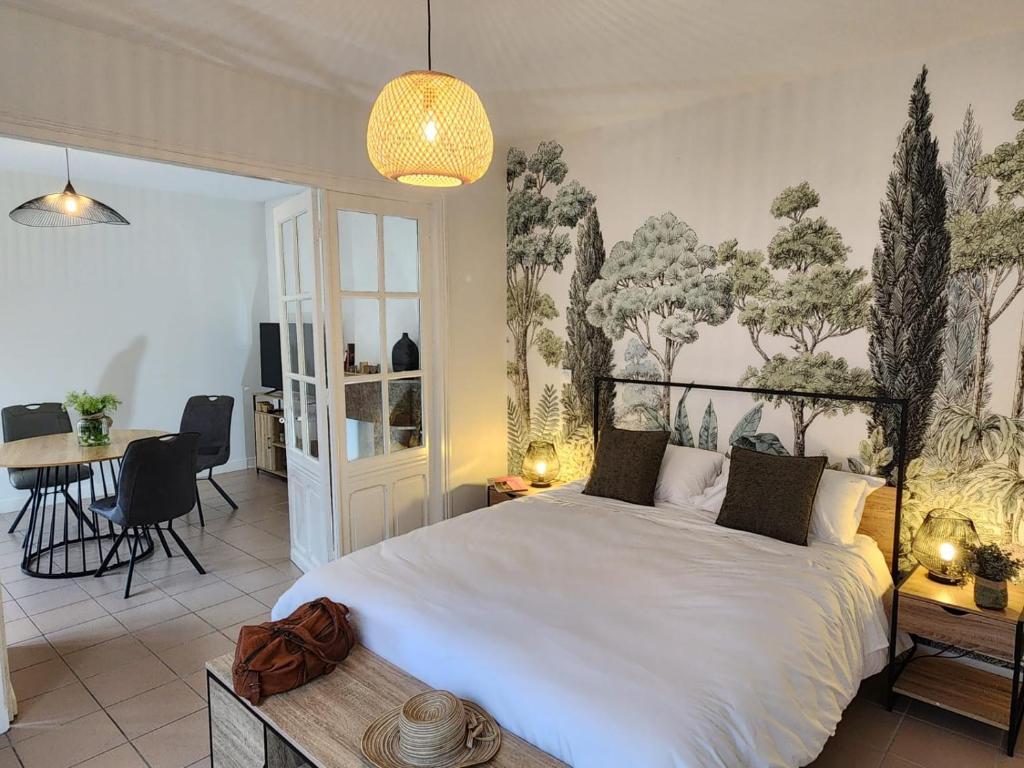 a bedroom with a large white bed and a table at Au fil de l'eau - Balcon, Spacieux, Confort, Calme, Wifi in Camblain-Châtelain