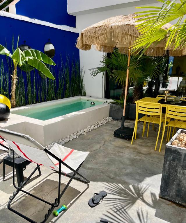 La salle de bains est pourvue d'une baignoire, d'une table et de chaises. dans l'établissement Maison avec bassin dans les remparts, à Aigues-Mortes