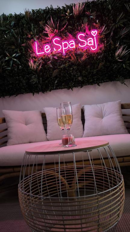- une table avec des verres à vin et un panneau indiquant le spa dans l'établissement Le Spa SAJ, à Émiéville