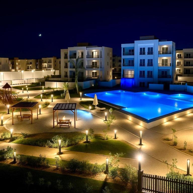 una grande piscina di notte con luci di Al Alamein North Coast A Luxury two Rooms Chalet at Amwaj a El Alamein