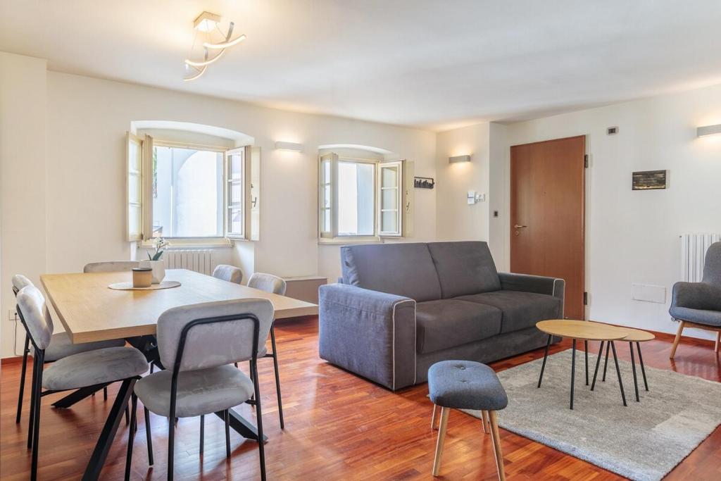 a living room with a couch and a table and chairs at Ancien Bazar Apartement in Aosta