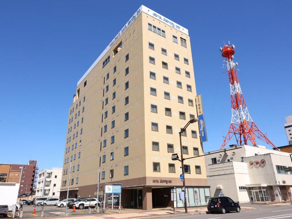 un edificio alto con una grúa encima en Dormy Inn Asahikawa, en Asahikawa