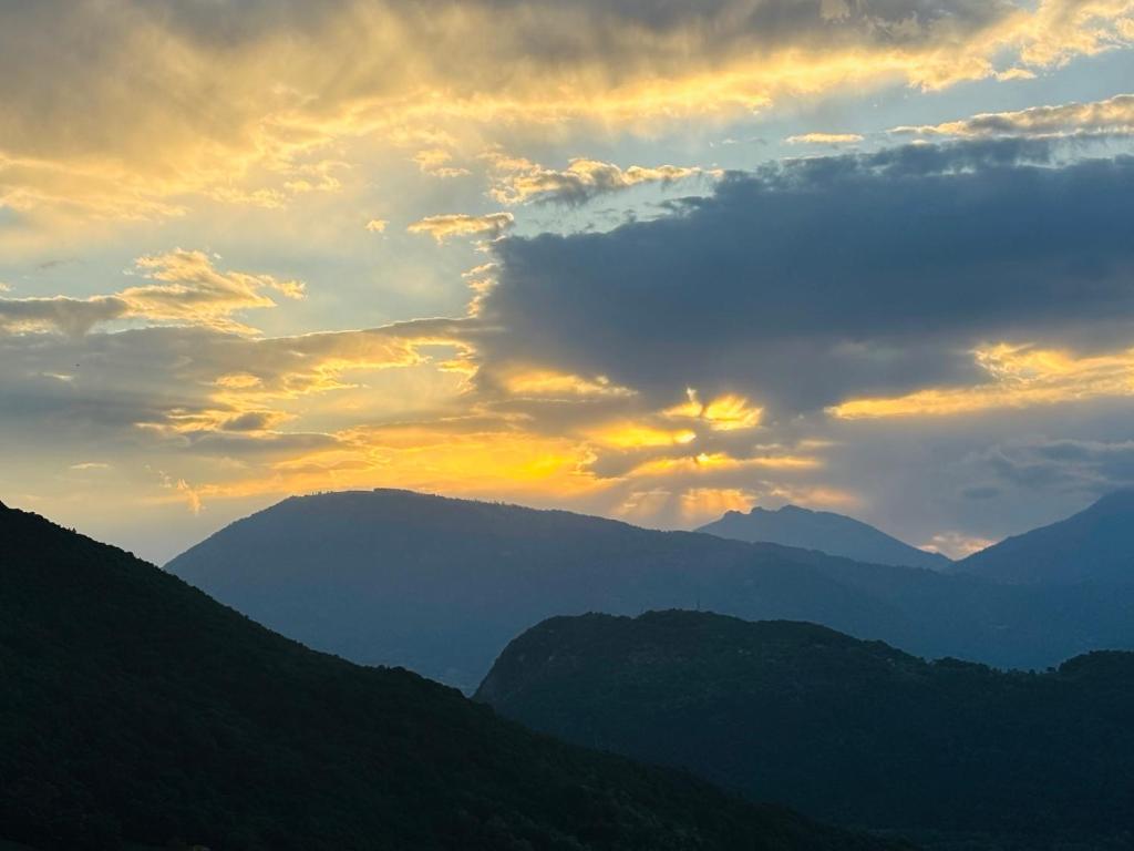 a sunset with mountains in the background and clouds at Agriturismo Saettà in Lentiai