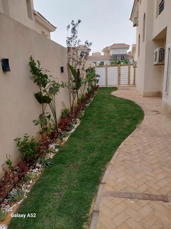 a walkway in a yard next to a building at كمبوند المقصد in Kafr ash Sharā‘inah