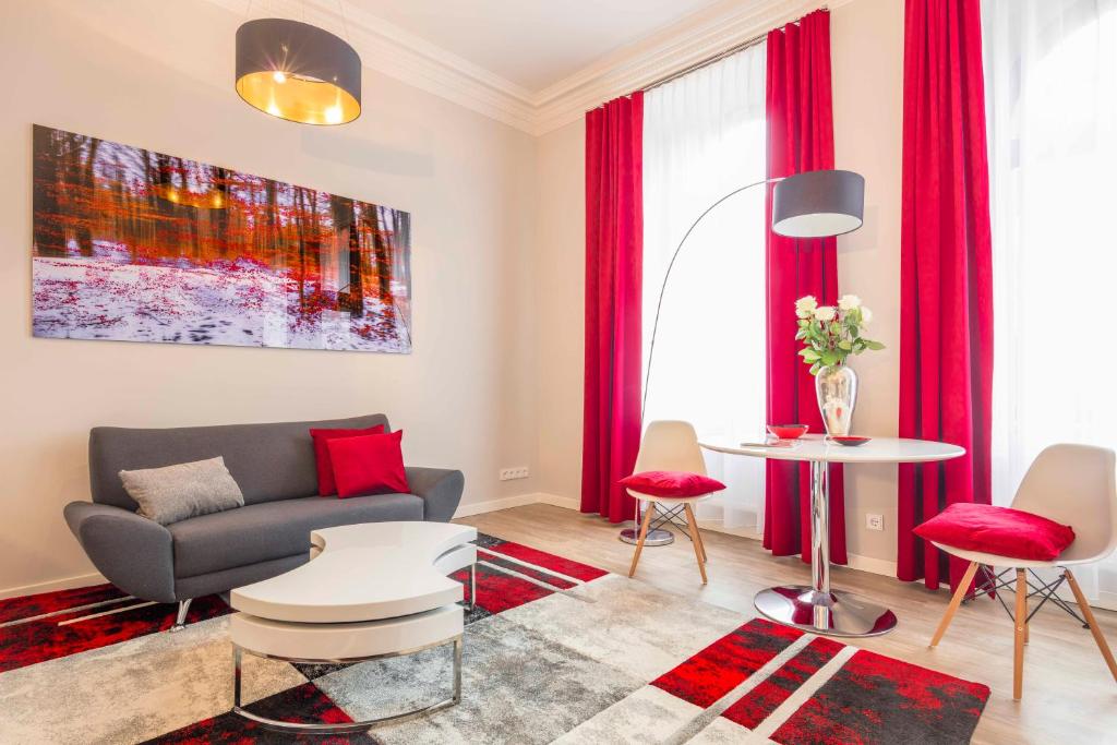 ein Wohnzimmer mit roten Vorhängen und einem Sofa in der Unterkunft Amalienhof Serviced Apartments in Weimar