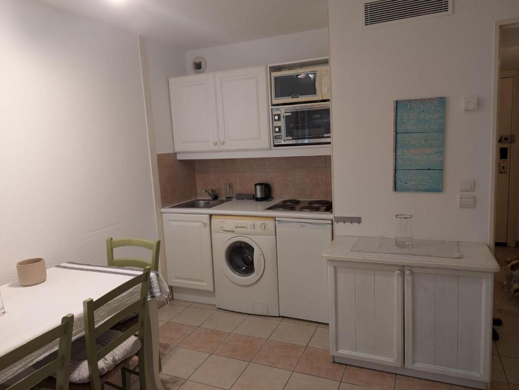 une cuisine avec un lave-linge et un micro-ondes dans l'établissement Studio Beausoleil Central MC, à Beausoleil