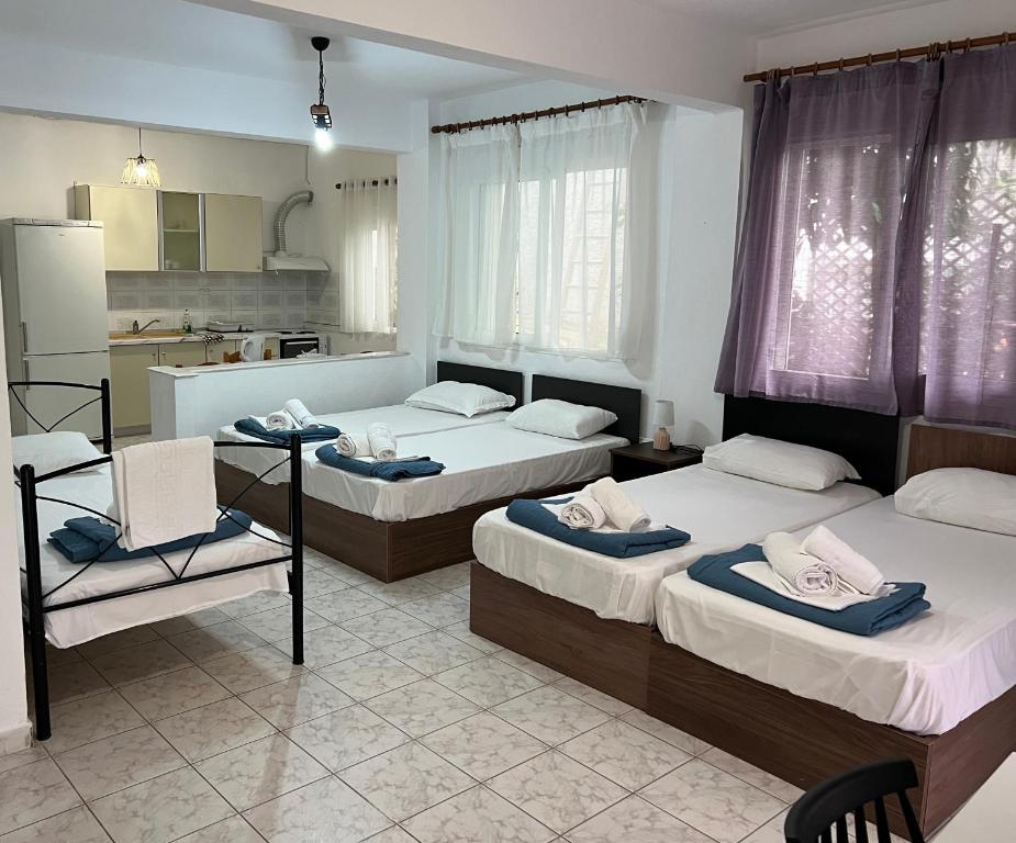 una camera con tre letti e una cucina di PELEKAN rooms and apartments athina 12 a Pefkohori