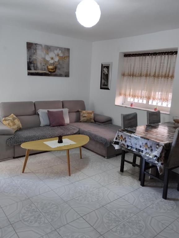 una sala de estar con un sofá y una mesa en Seaside Break Apartment, en Sarandë