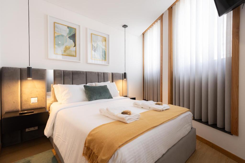 ein Schlafzimmer mit einem großen Bett mit Handtüchern darauf in der Unterkunft Coruja’s House AL OPO in Porto