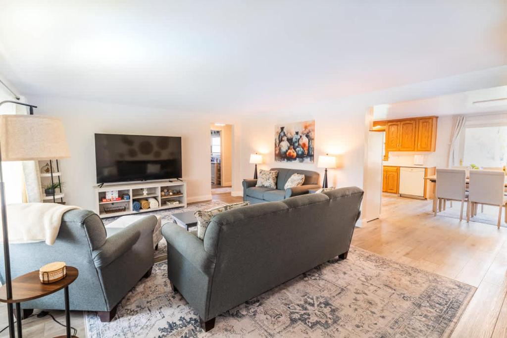 Sleeps 6 Walk to Lambeau Resch Dog-Friendly في غرين باي: غرفة معيشة مع أريكة وتلفزيون