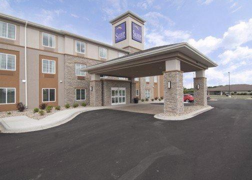 un bâtiment avec une tour d'horloge dans un parking dans l'établissement Sleep Inn & Suites Marshall, à Marshall