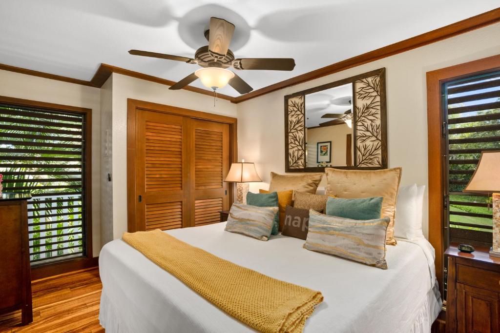 科洛阿Kauai Kiahuna Plantation #425 by Coldwell Banker Island Vacations的卧室配有白色的床和吊扇