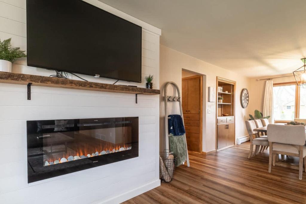 Stadium District Resch 3 BR Sleeps 8 في غرين باي: غرفة معيشة مع موقد وتلفزيون فوقها