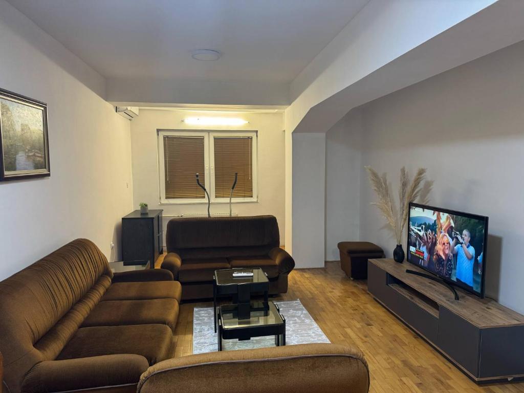 a living room with a couch and a flat screen tv at VD Apartment 2 ,only 5 min from main Bus Station in Skopje