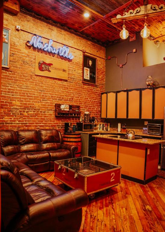 a living room with leather furniture and a brick wall at The Law Suites in Nashville
