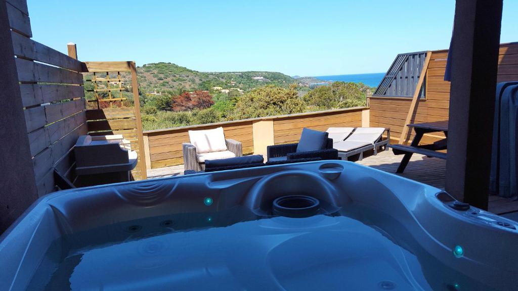 une baignoire bleue assise sur un balcon avec des chaises dans l'établissement Appartement Cemiliana, à Bonifacio