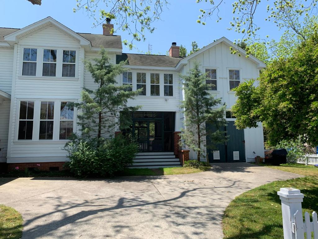 a white house with a black door at Cameron House Next Door in Manteo