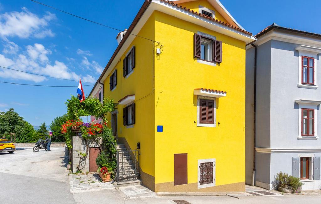 a yellow building with flowers on the side of it at Castua Residence in Kastav