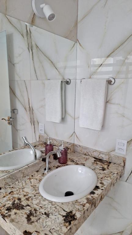 a bathroom with a sink and a counter with towels at Recanto Pau Brasil in Sete Lagoas