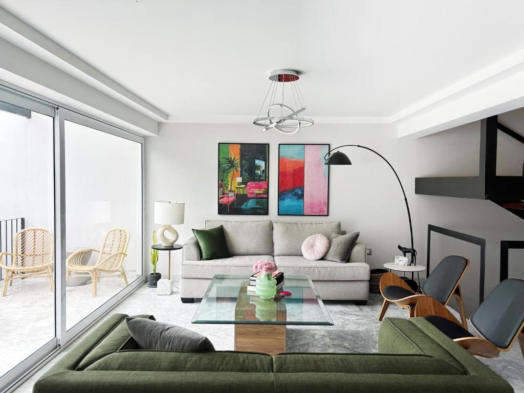 een woonkamer met een bank en een tafel bij Casa Loma next to Xochimilco in Oaxaca City