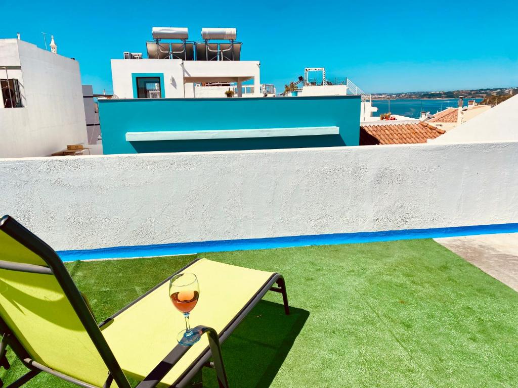 un tavolo con un bicchiere di vino seduto su un balcone di Bia Vintage Villa - Casa com Vista Mar, Terraço e Jardim no Centro de Alvor ad Alvor