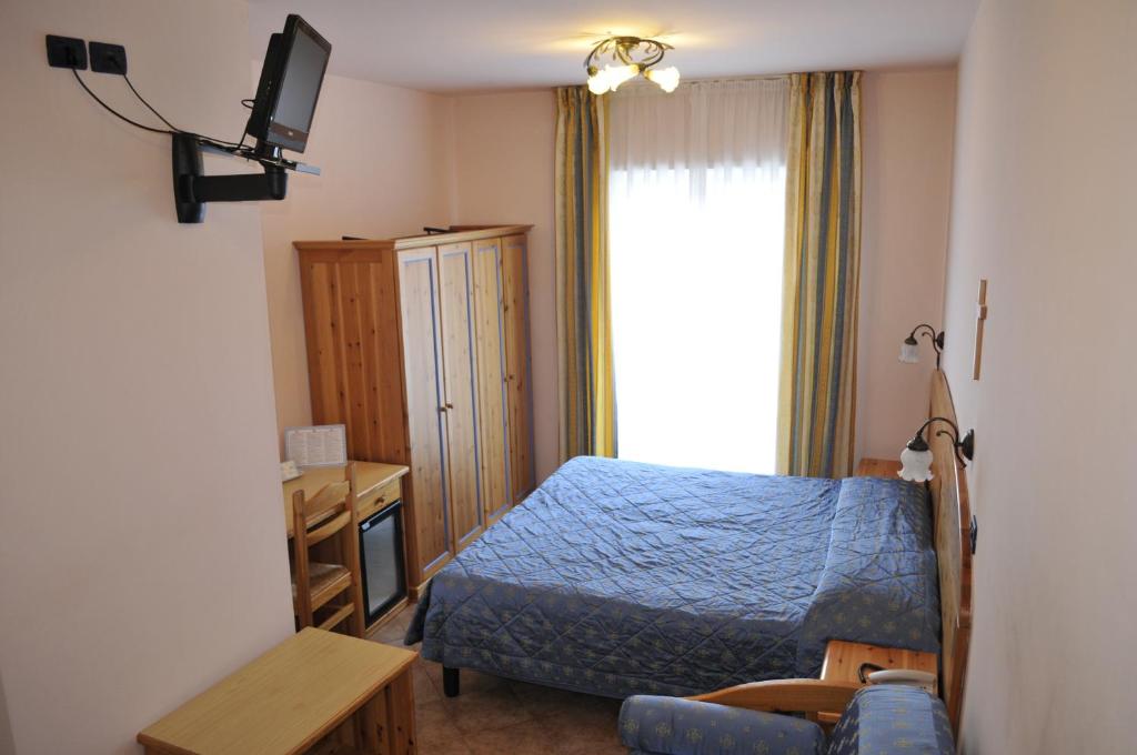 a bedroom with a blue bed and a window at Hotel Vittoria in Riva del Garda