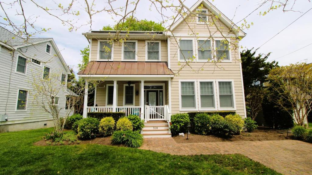 ein Haus mit einer Veranda und einem weißen Haus in der Unterkunft 320 Knox Avenue, Cape May Point in Cape May Point
