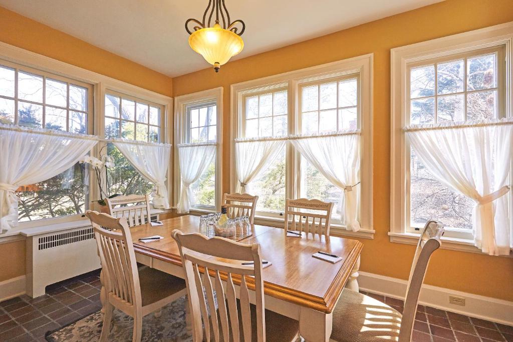 a dining room with a table and chairs and windows at The Inn on Bay in Gravenhurst