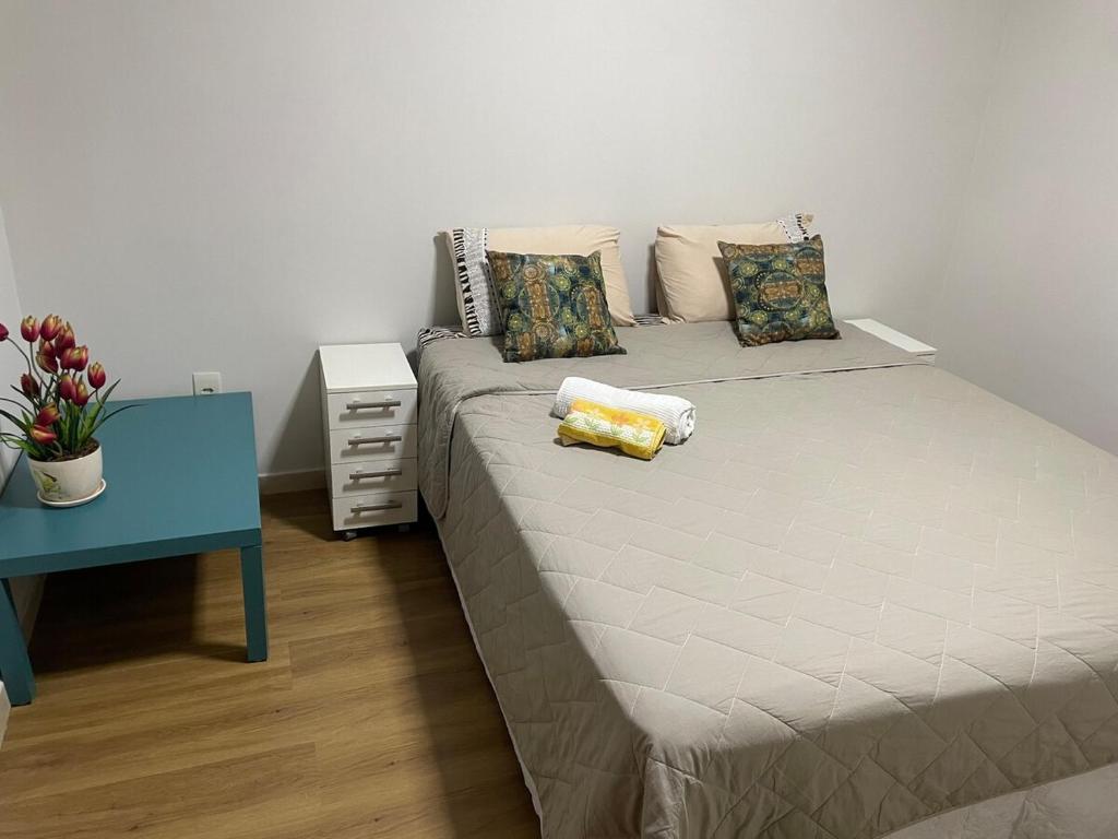 a bed in a room with a blue table and a bed at Riacho Fundo I 201- Boa acomodação com economia in Brasilia